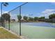 A tennis court is enclosed by a black chain-link fence surrounded by trees and landscaping at 1295 Aster Ives Dr, Lawrenceville, GA 30045