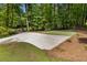 Spacious backyard with a concrete patio and a grass area, surrounded by mature trees and lush greenery at 1461 Bubbling Creek Ne Rd, Brookhaven, GA 30319