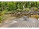 Backyard deck with table, chairs, retaining wall with plants and fencing creating a private space at 1461 Bubbling Creek Ne Rd, Brookhaven, GA 30319