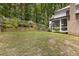 A serene backyard featuring lush green grass, terraced landscaping, a back deck and white siding at 1461 Bubbling Creek Ne Rd, Brookhaven, GA 30319