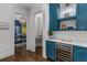 Stylish bar area with blue cabinets, wine cooler, and decorative shelving at 1461 Bubbling Creek Ne Rd, Brookhaven, GA 30319