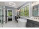 Bright bathroom showcasing a soaking tub, double vanity, modern fixtures, and a view to the bedroom at 1461 Bubbling Creek Ne Rd, Brookhaven, GA 30319