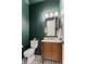 Stylish powder room featuring dark green walls, updated vanity, gold fixtures and elegant black and white tile flooring at 1461 Bubbling Creek Ne Rd, Brookhaven, GA 30319