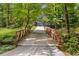Scenic view of a bridge that spans a stream, leading up a winding driveway to the home at 1461 Bubbling Creek Ne Rd, Brookhaven, GA 30319