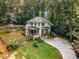 A charming white two-story home featuring manicured lawn and wooded surroundings at 1461 Bubbling Creek Ne Rd, Brookhaven, GA 30319