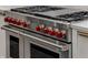 The gourmet kitchen features a Wolf brand stainless steel oven and range with red knobs at 1461 Bubbling Creek Ne Rd, Brookhaven, GA 30319