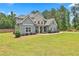 Two-story home with stone accents, well-manicured lawn, and mature landscaping at 33 Vinery Ct, Sharpsburg, GA 30277