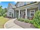 Inviting front porch with stone pillars, seating, and landscaped surroundings at 33 Vinery Ct, Sharpsburg, GA 30277