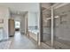 Bright main bathroom featuring a glass shower, soaking tub, and tile flooring at 33 Vinery Ct, Sharpsburg, GA 30277