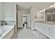 Well-lit main bathroom with tiled floor, separate shower, and soaking tub at 33 Vinery Ct, Sharpsburg, GA 30277