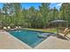Beautiful swimming pool with built-in stairs and a sundeck, surrounded by lush greenery and lounge seating at 33 Vinery Ct, Sharpsburg, GA 30277