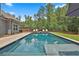 Backyard swimming pool surrounded by a well-maintained lawn, tall trees, and comfortable lounge chairs at 33 Vinery Ct, Sharpsburg, GA 30277