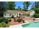 A backyard with a brick patio, outdoor furniture, swimming pool, and lush landscaping at 5545 Cross Gate Ct, Atlanta, GA 30327