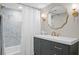 Stylish bathroom with a modern vanity, decorative mirror, and tub with marble tiling at 5545 Cross Gate Ct, Atlanta, GA 30327