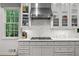 Close up of kitchen with Wolf gas range, marble backsplash, and custom white cabinetry at 5545 Cross Gate Ct, Atlanta, GA 30327