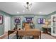 A stylish home office features a wood desk, modern light fixture and sports memorabilia for an inspiring workspace at 5545 Cross Gate Ct, Atlanta, GA 30327