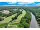 Scenic aerial view of the lush golf course and country club with a river running alongside it at 5623 Brendlynn Dr, Suwanee, GA 30024