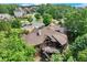 Aerial view of a beautiful home with an expansive deck nestled among lush green trees and neighboring homes at 5623 Brendlynn Dr, Suwanee, GA 30024