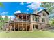 Expansive two-story home featuring a covered patio, a large deck and a lush green lawn at 5623 Brendlynn Dr, Suwanee, GA 30024