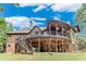 Expansive two-story home featuring a covered patio, a large deck with stairs and a lush green lawn at 5623 Brendlynn Dr, Suwanee, GA 30024