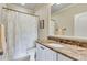 Elegant bathroom with marble countertop, decorative mirror, and shower with curtain at 5623 Brendlynn Dr, Suwanee, GA 30024
