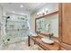 A bright bathroom is equipped with a dual sink vanity and a large glass enclosed shower at 5623 Brendlynn Dr, Suwanee, GA 30024