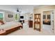 This bedroom features a ceiling fan, a TV, windows with green landscape views, as well as furniture for storage and display at 5623 Brendlynn Dr, Suwanee, GA 30024
