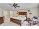 The bedroom boasts a ceiling fan, a large wooden bed frame, and sits on a carpeted floor at 5623 Brendlynn Dr, Suwanee, GA 30024