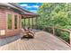 Beautiful curved deck with stained wood, railing and seating, surrounded by trees at 5623 Brendlynn Dr, Suwanee, GA 30024