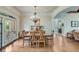 Elegant dining room with hardwood floors, chandelier, and access to the outdoor patio at 5623 Brendlynn Dr, Suwanee, GA 30024
