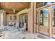 Inviting front porch with stone floor, brick columns, and wooden front door offers comfortable outdoor seating at 5623 Brendlynn Dr, Suwanee, GA 30024
