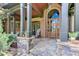 Inviting front porch with stone base columns, stone tile flooring, brick and wood trim, and lovely plants at 5623 Brendlynn Dr, Suwanee, GA 30024