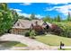 Charming two-story home with manicured lawn, brick and stone exterior, and a long driveway at 5623 Brendlynn Dr, Suwanee, GA 30024