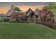 Beautiful brick home with lush front lawn, landscaping, and vibrant trees as the sun sets at 5623 Brendlynn Dr, Suwanee, GA 30024