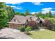 Charming two-story home with manicured lawn, brick and stone exterior, and three-car garage at 5623 Brendlynn Dr, Suwanee, GA 30024