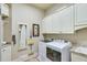 Well-organized laundry room featuring cabinetry, granite countertops, a utility sink, and modern appliances at 5623 Brendlynn Dr, Suwanee, GA 30024