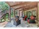 Covered patio with stone flooring, comfortable seating, and wooded views at 5623 Brendlynn Dr, Suwanee, GA 30024