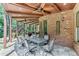 Large covered patio with stone flooring offers ample dining and seating with a view of the backyard at 5623 Brendlynn Dr, Suwanee, GA 30024