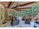 Spacious covered patio with stone floor, seating, fan, and wooded views offers outdoor living space at 5623 Brendlynn Dr, Suwanee, GA 30024