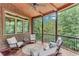 Cozy screened porch with wood floors and comfortable seating overlooking the lush backyard at 5623 Brendlynn Dr, Suwanee, GA 30024
