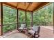 Screened-in porch with wooden floors and comfortable seating overlooking a wooded area at 5623 Brendlynn Dr, Suwanee, GA 30024