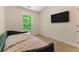 Comfortable bedroom featuring carpet floors, a window view, and a large wall-mounted TV at 1689 Camden Forrest Way, Riverdale, GA 30296