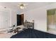 Cozy bedroom with a ceiling fan, neutral colored walls, and a door leading to the ensuite bathroom at 1689 Camden Forrest Way, Riverdale, GA 30296