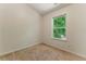 Neutral-colored bedroom with a large window showing the greenery outside for natural lighting at 1689 Camden Forrest Way, Riverdale, GA 30296