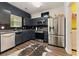 Contemporary kitchen featuring stainless steel appliances, dark cabinetry, and sleek backsplash at 1689 Camden Forrest Way, Riverdale, GA 30296