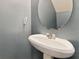 Neat half bathroom featuring pedestal sink and an oval mirror at 1689 Camden Forrest Way, Riverdale, GA 30296