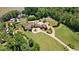 Expansive estate featuring a circular driveway, lush lawn, and mature trees creating a private oasis at 2220 Peachtree Rd, Cumming, GA 30041