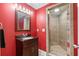 Bright bathroom with modern shower stall, cherry vanity, and red walls at 2220 Peachtree Rd, Cumming, GA 30041