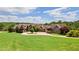 Expansive front lawn and circular driveway leading to a custom home with mature trees at 2220 Peachtree Rd, Cumming, GA 30041