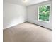 Bright bedroom with neutral carpet, white walls and large window providing ample natural light at 6560 Alford Way, Lithonia, GA 30058